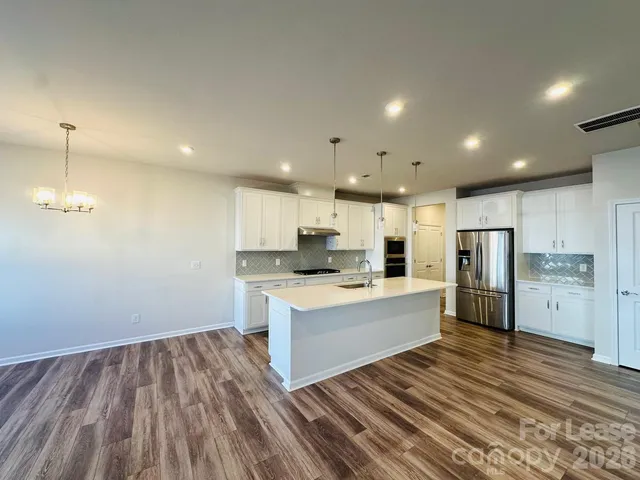 a large kitchen with a lot of counter space and stainless steel appliances