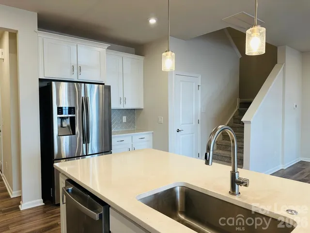 a kitchen with kitchen island a sink appliances and wooden floor