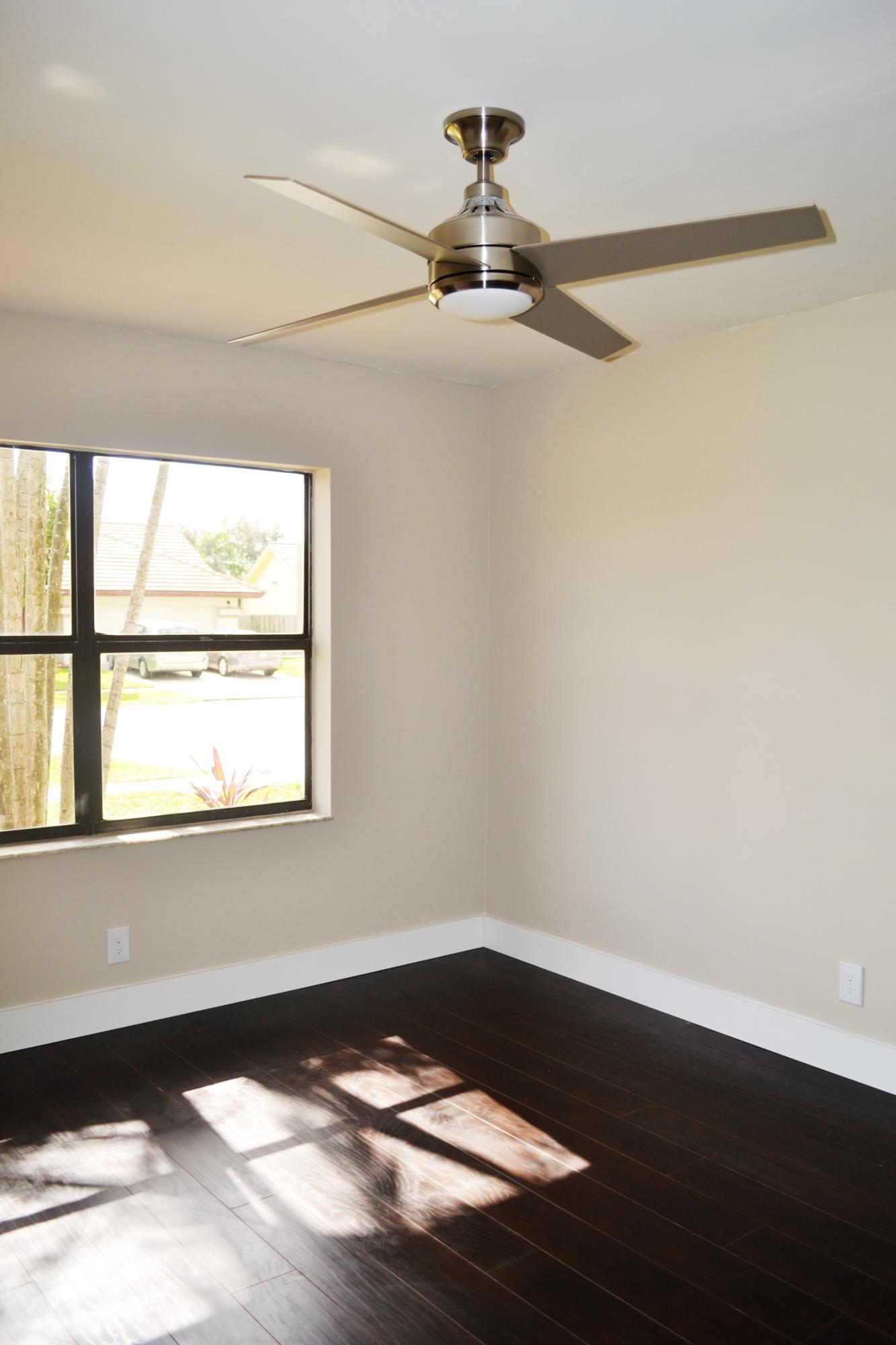 9540 El Clair Ranch Road Boynton Beach, FL 33437 - Photo 13 of 26 a view of an empty room with wooden floor and a window