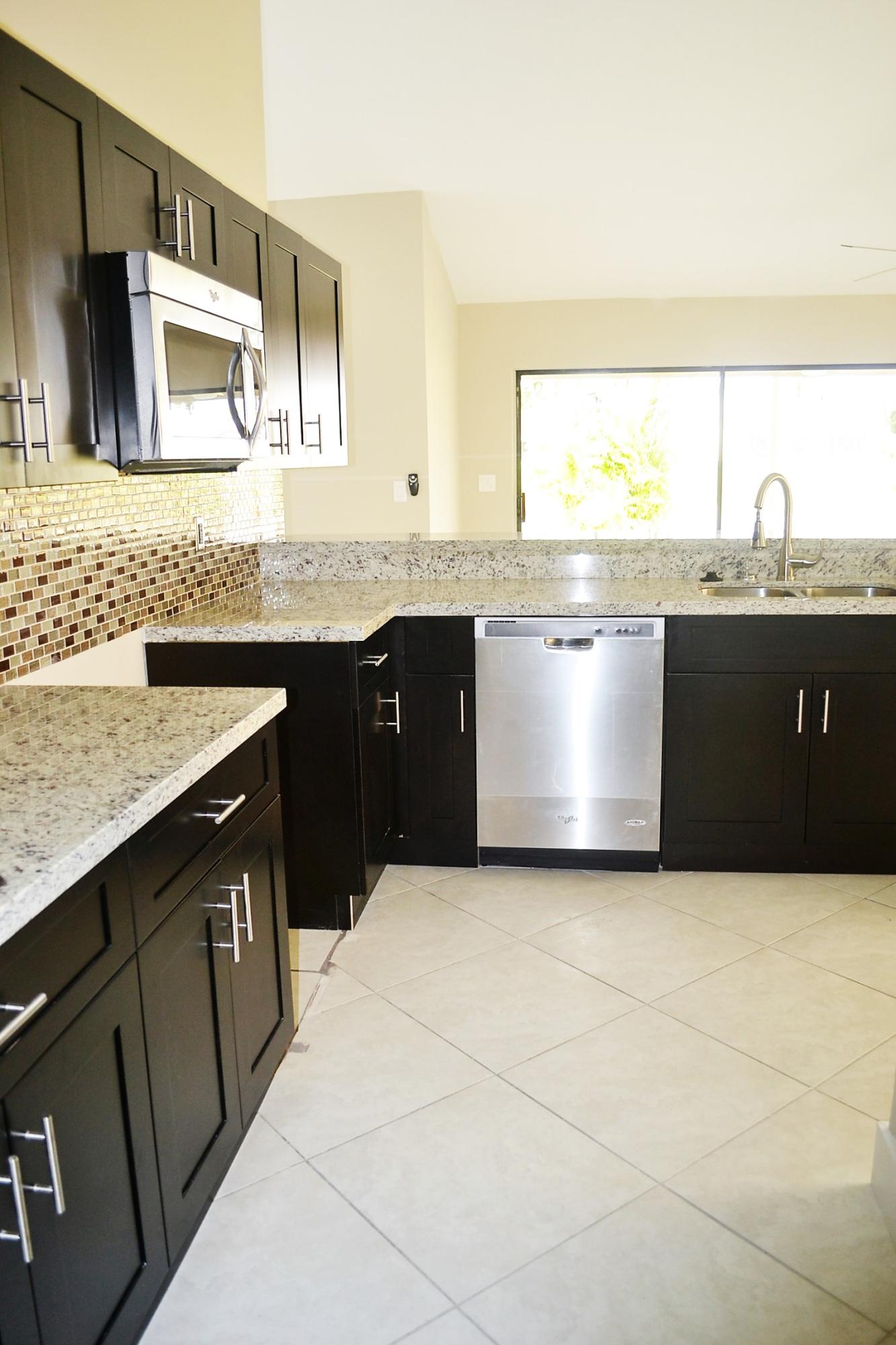 9540 El Clair Ranch Road Boynton Beach, FL 33437 - Photo 7 of 26 a kitchen with stainless steel appliances granite countertop a sink and a stove