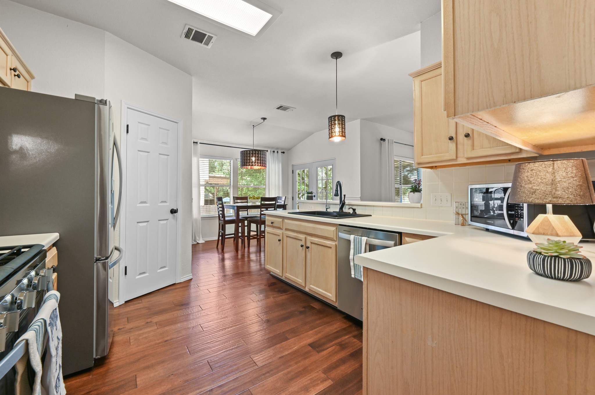 1409 Knoll Ridge Drive Cedar Park, TX 78613 - Photo 14 of 30 A well-appointed kitchen features rich hardwood flooring and a functional layout leading to a bright dining area.