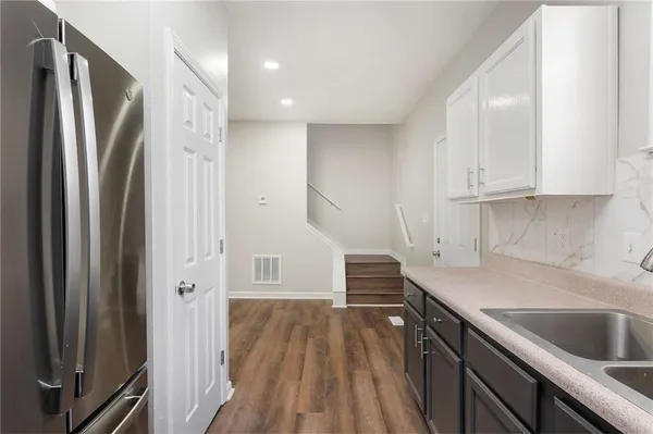 a kitchen with white cabinets and stainless steel appliances