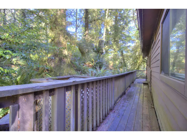 a balcony with wooden floor and yard in the back