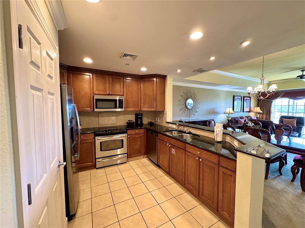 1350 Centre Ct Ridge Drive, Unit 401 Reunion, FL 34747 - Photo 12 of 32 a kitchen with stainless steel appliances granite countertop a sink and cabinets