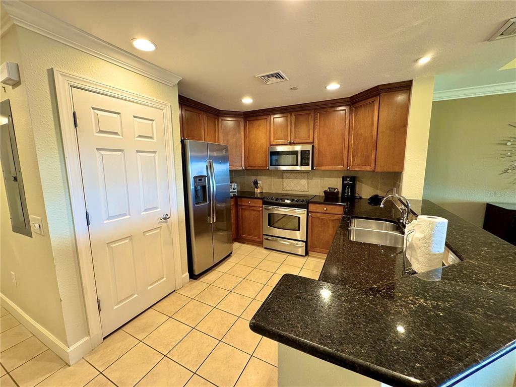1350 Centre Ct Ridge Drive, Unit 401 Reunion, FL 34747 - Photo 13 of 32 a kitchen with stainless steel appliances granite countertop a refrigerator a stove and a sink