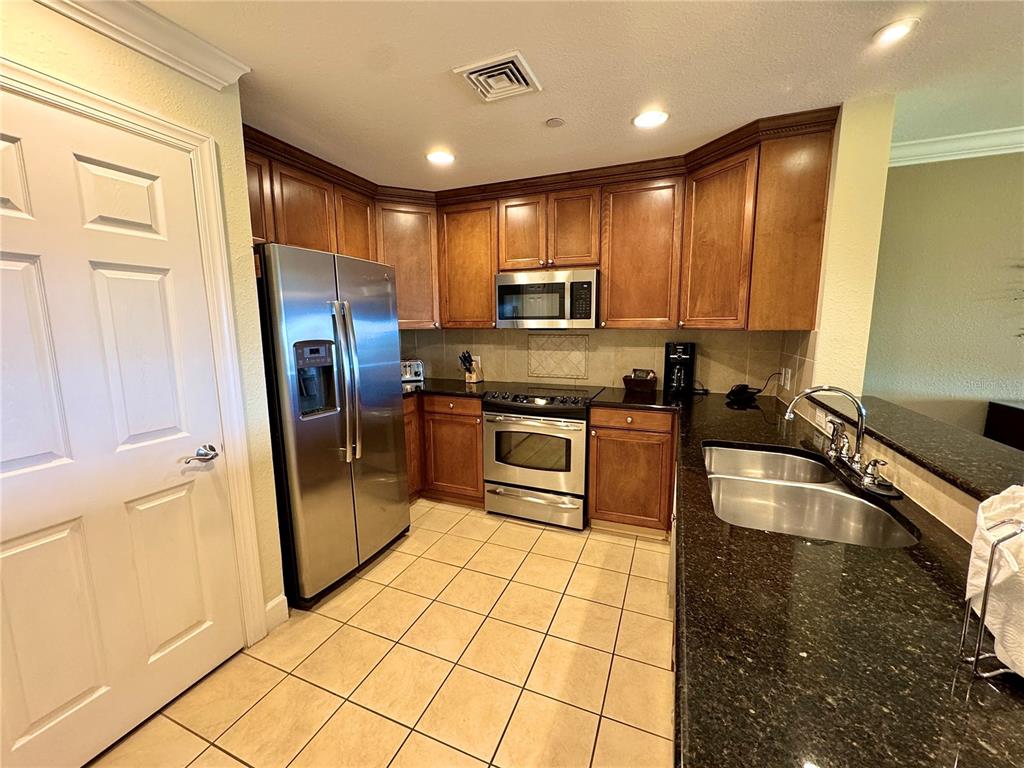 1350 Centre Ct Ridge Drive, Unit 401 Reunion, FL 34747 - Photo 14 of 32 a kitchen with stainless steel appliances granite countertop a refrigerator a stove and a sink