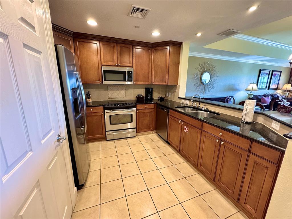 1350 Centre Ct Ridge Drive, Unit 401 Reunion, FL 34747 - Photo 15 of 32 a kitchen with stainless steel appliances a stove a sink and a refrigerator