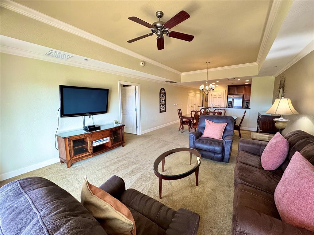 1350 Centre Ct Ridge Drive, Unit 401 Reunion, FL 34747 - Photo 20 of 32 a living room with furniture a flat screen tv and kitchen view