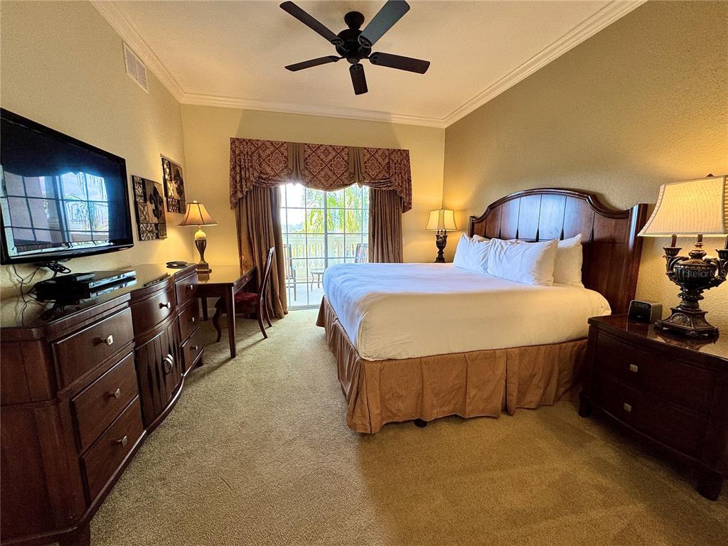1350 Centre Ct Ridge Drive, Unit 401 Reunion, FL 34747 - Photo 23 of 32 a bedroom with a bed and dresser with wooden floor