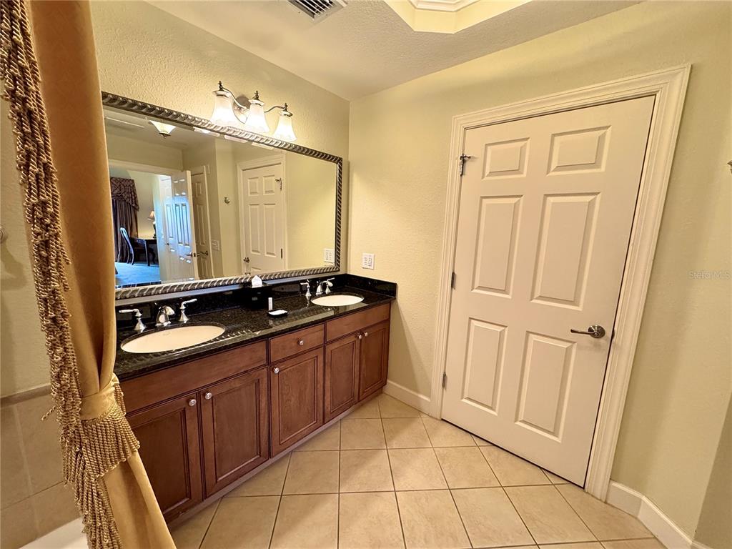 1350 Centre Ct Ridge Drive, Unit 401 Reunion, FL 34747 - Photo 27 of 32 a bathroom with a granite countertop sink and a mirror