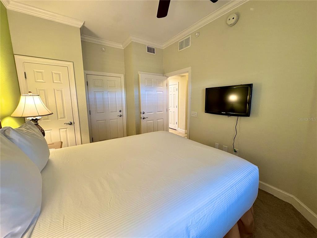 1350 Centre Ct Ridge Drive, Unit 401 Reunion, FL 34747 - Photo 4 of 32 a bedroom with a bed and a flat screen tv