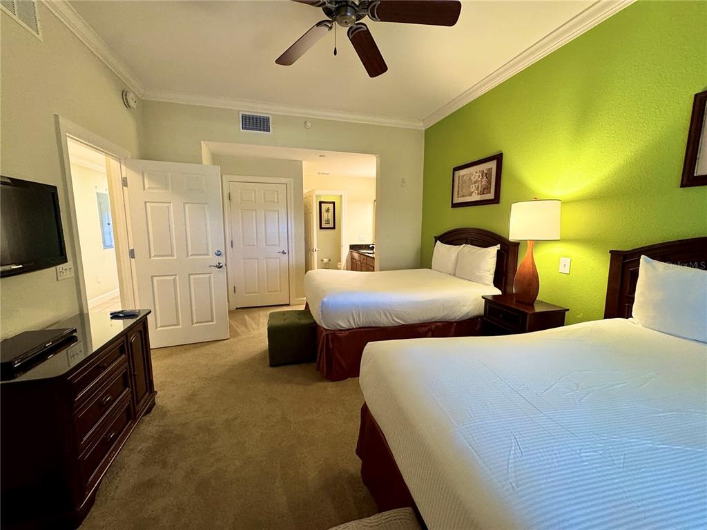 1350 Centre Ct Ridge Drive, Unit 401 Reunion, FL 34747 - Photo 6 of 32 a bedroom with a bed and a flat screen tv