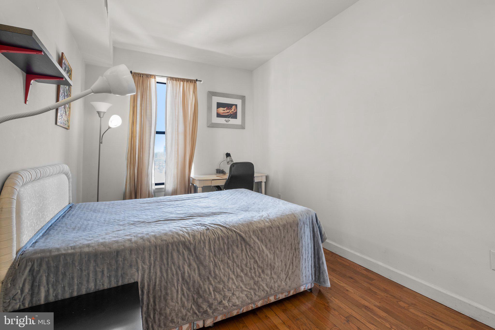 1763 Columbia Road Northwest, Unit 510 Washington, DC 20009 - Photo 13 of 17 a bedroom with a bed and wooden floor