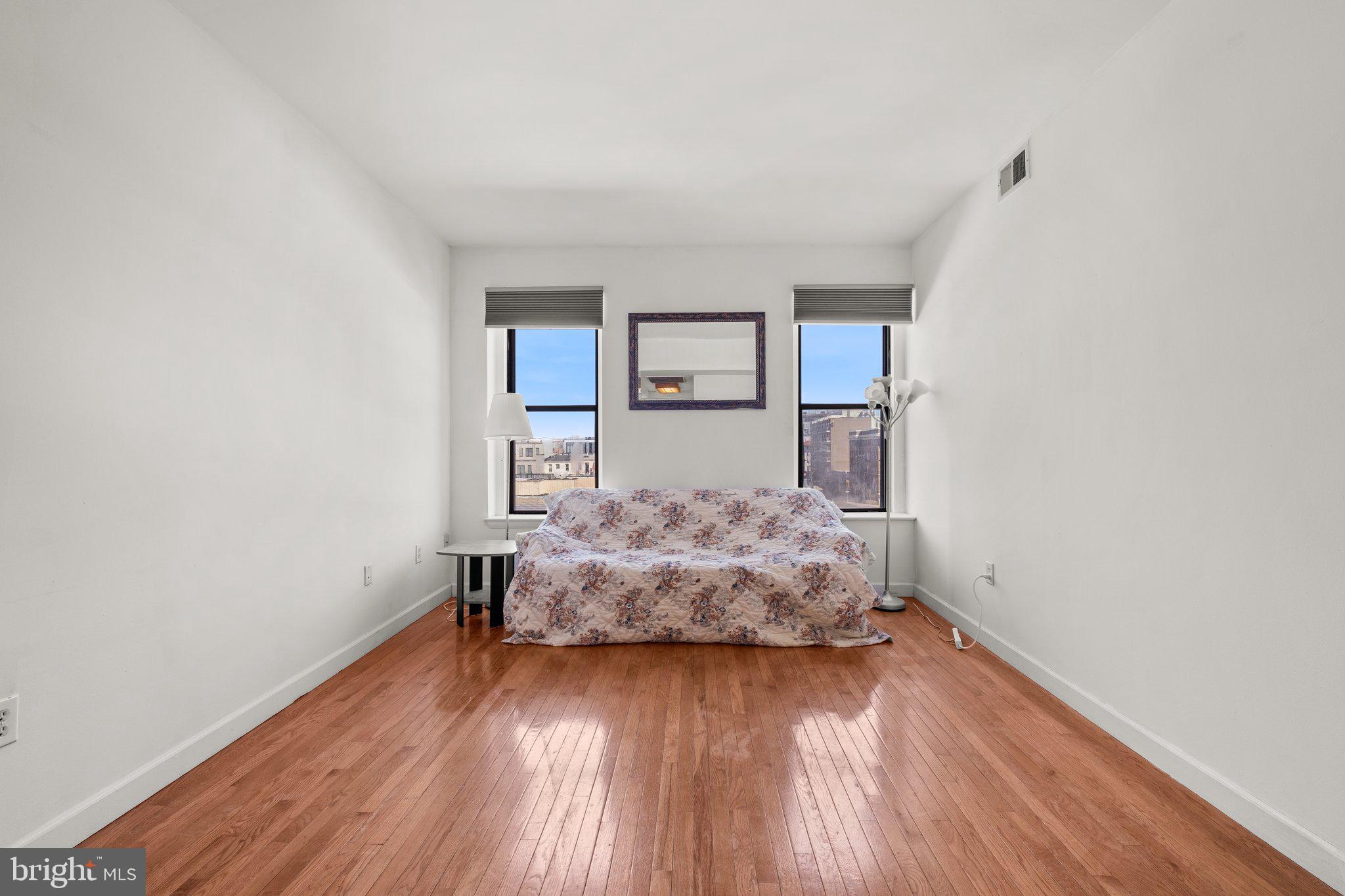 1763 Columbia Road Northwest, Unit 510 Washington, DC 20009 - Photo 4 of 17 a living room with a bed furniture and wooden floor