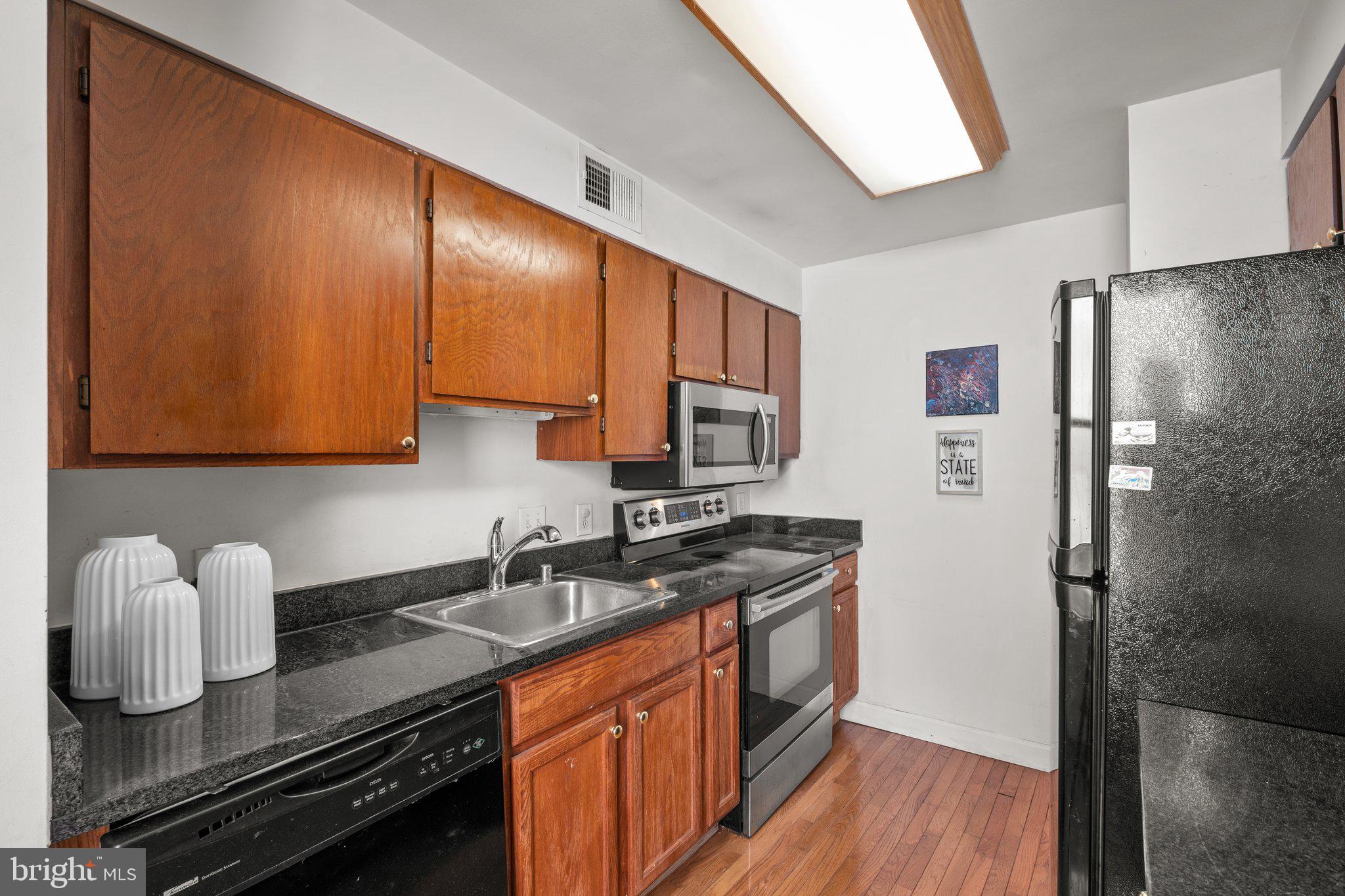 1763 Columbia Road Northwest, Unit 510 Washington, DC 20009 - Photo 6 of 17 a kitchen with stainless steel appliances granite countertop a sink stove and refrigerator