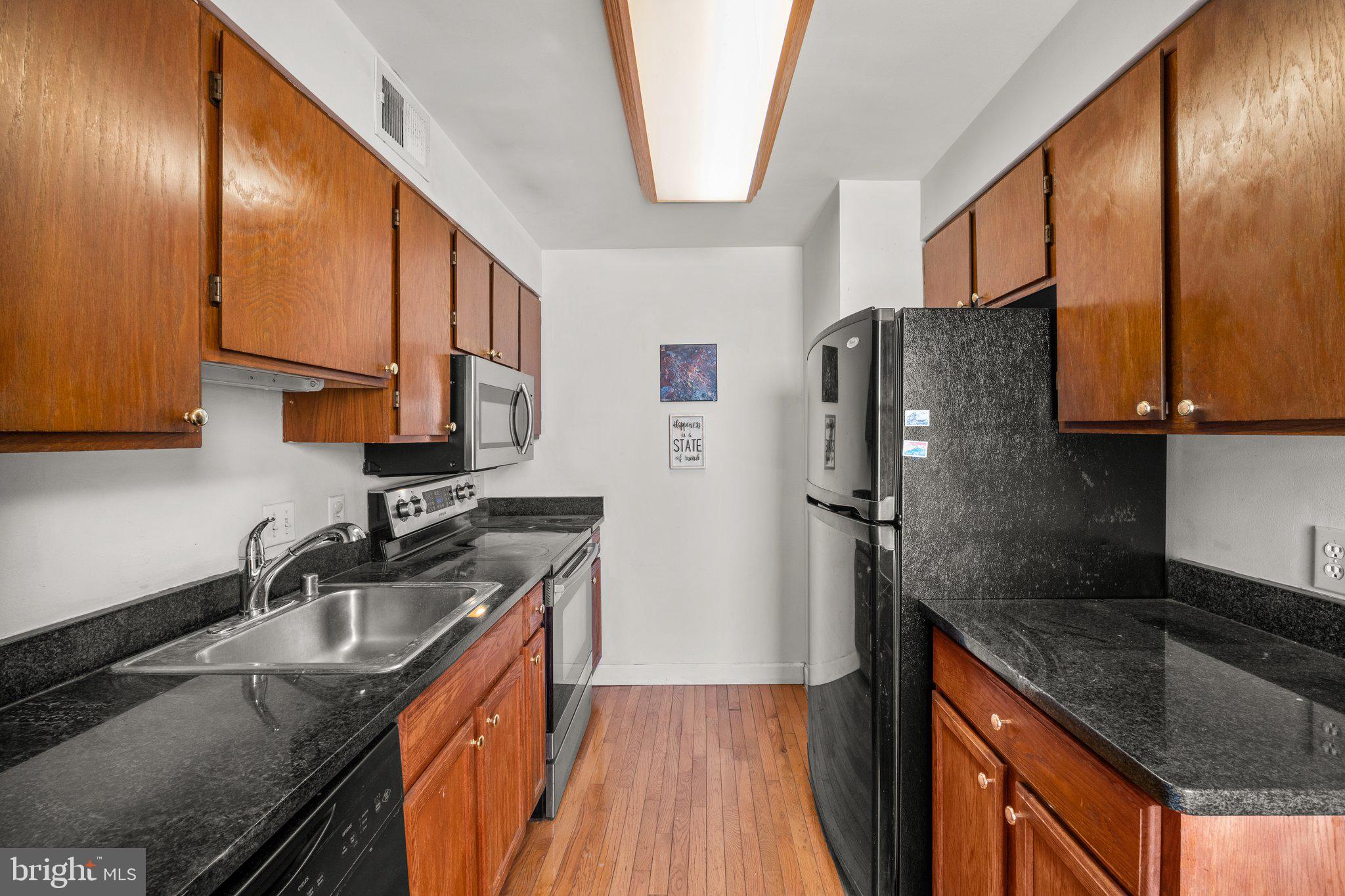 1763 Columbia Road Northwest, Unit 510 Washington, DC 20009 - Photo 7 of 17 a kitchen with stainless steel appliances granite countertop a sink stove and refrigerator