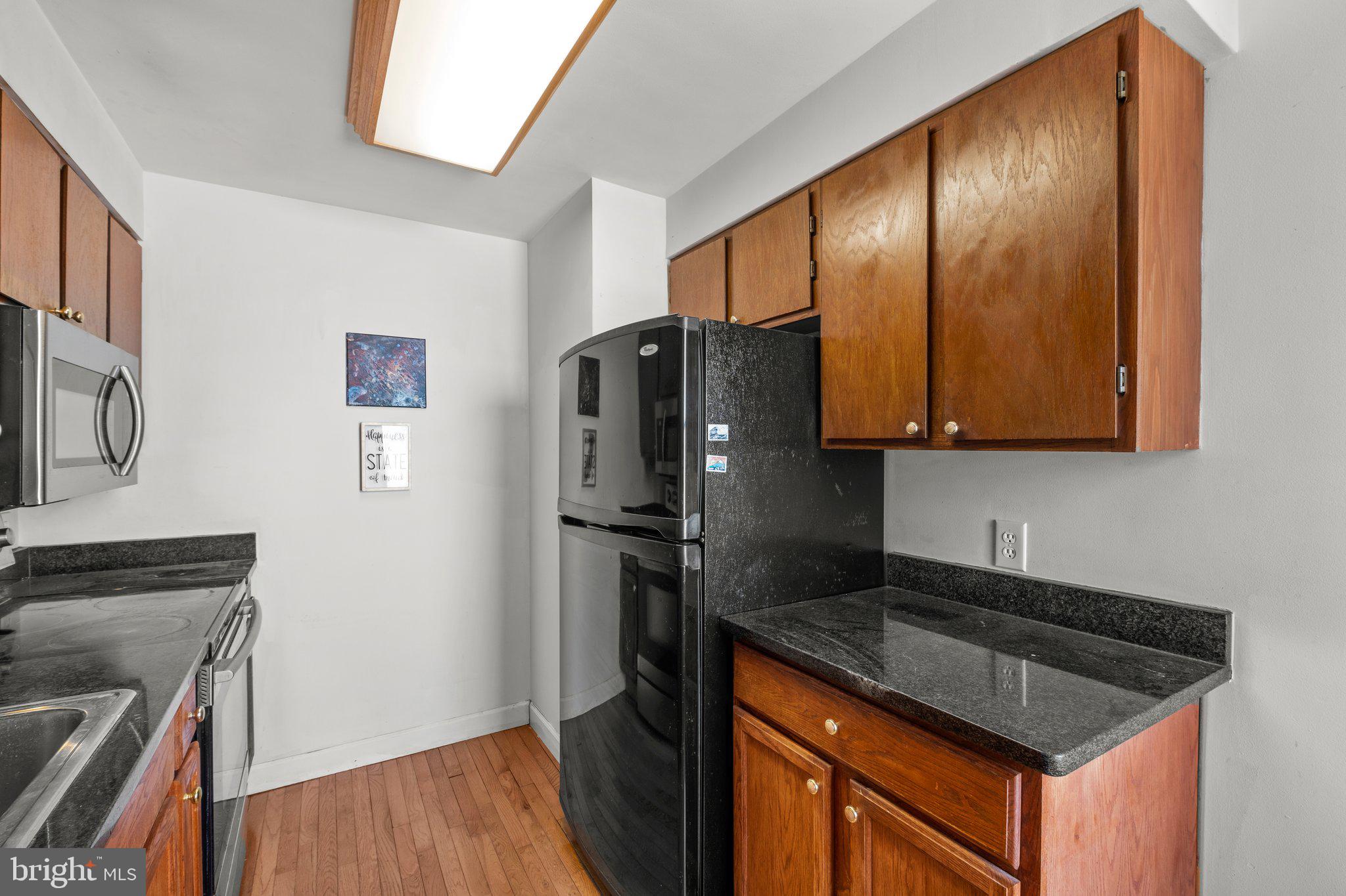 1763 Columbia Road Northwest, Unit 510 Washington, DC 20009 - Photo 10 of 17 a kitchen with granite countertop stainless steel appliances a refrigerator stove top oven and sink