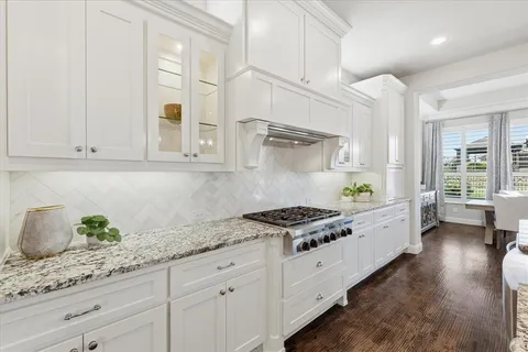 a kitchen with granite countertop white cabinets and white stainless steel appliances
