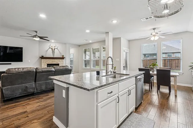 a kitchen with stainless steel appliances granite countertop a sink stove and wooden floor