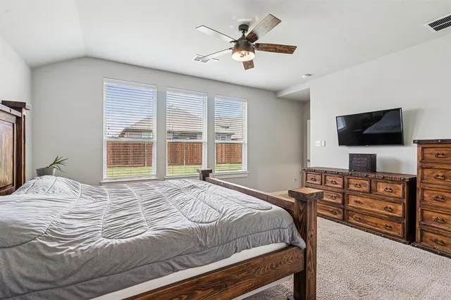 a bedroom with a bed and a flat screen tv on dresser