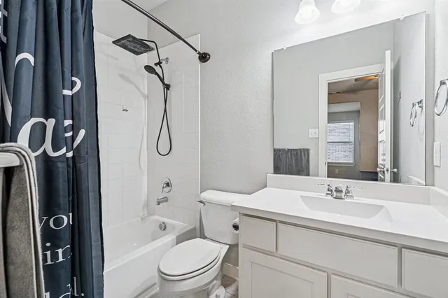 a bathroom with a granite countertop sink a toilet and shower