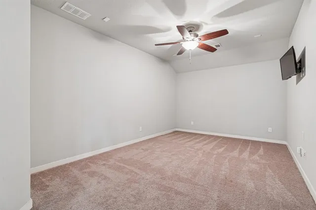an empty room with ceiling fan and window