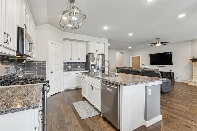 a kitchen with stainless steel appliances granite countertop a stove oven and a sink