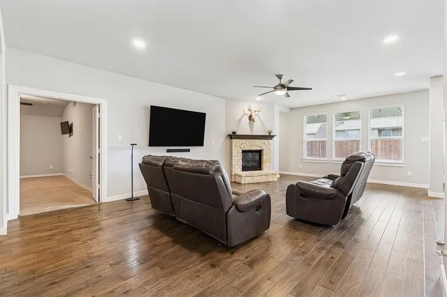 a living room with furniture flat screen tv and wooden floor