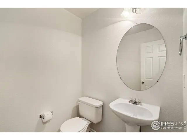 a bedroom with a bed a chair and a chandelier