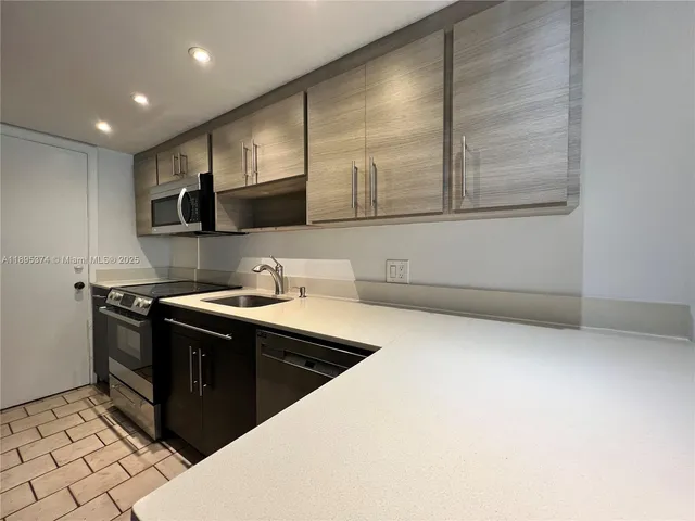 a kitchen with stainless steel appliances granite countertop a sink and a stove