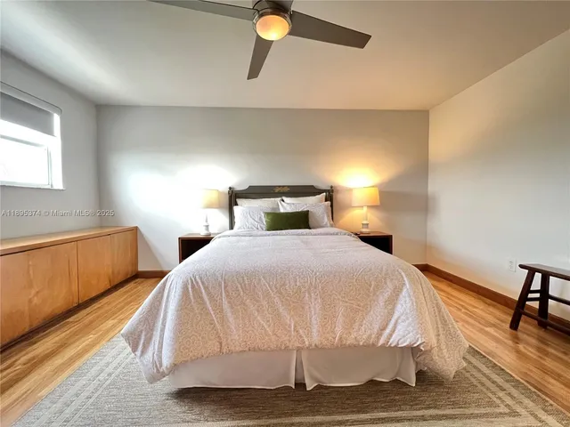a bedroom with two beds and a potted plant