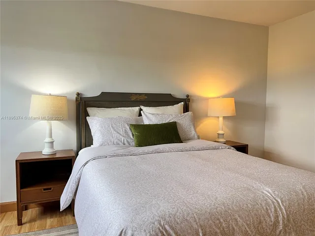 a large bed sitting in a bedroom with a lamp
