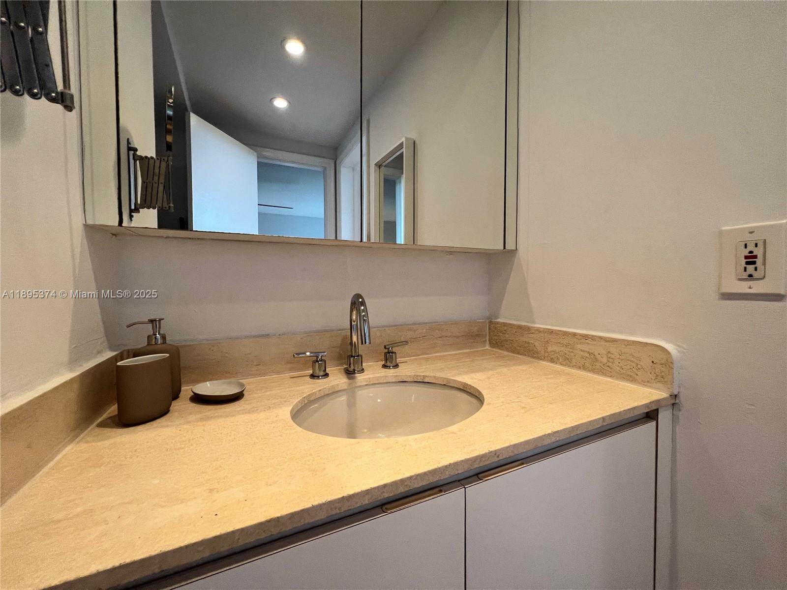 555 Crandon Boulevard, Unit 53 Key Biscayne, FL 33149 - Photo 21 of 33 a bathroom with a sink and a mirror