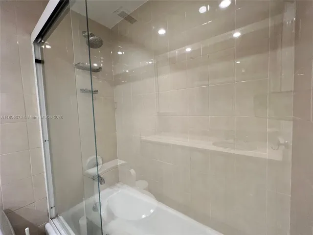 a bathroom with a shower and a glass door