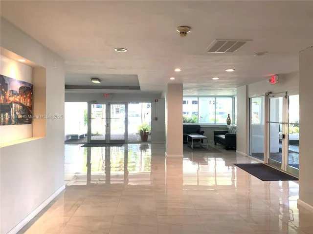 a view of a big room with windows and chandelier