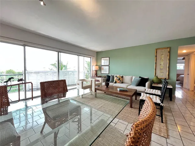 a living room with furniture and large windows