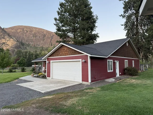 a view of a yard in front of a house with large tree