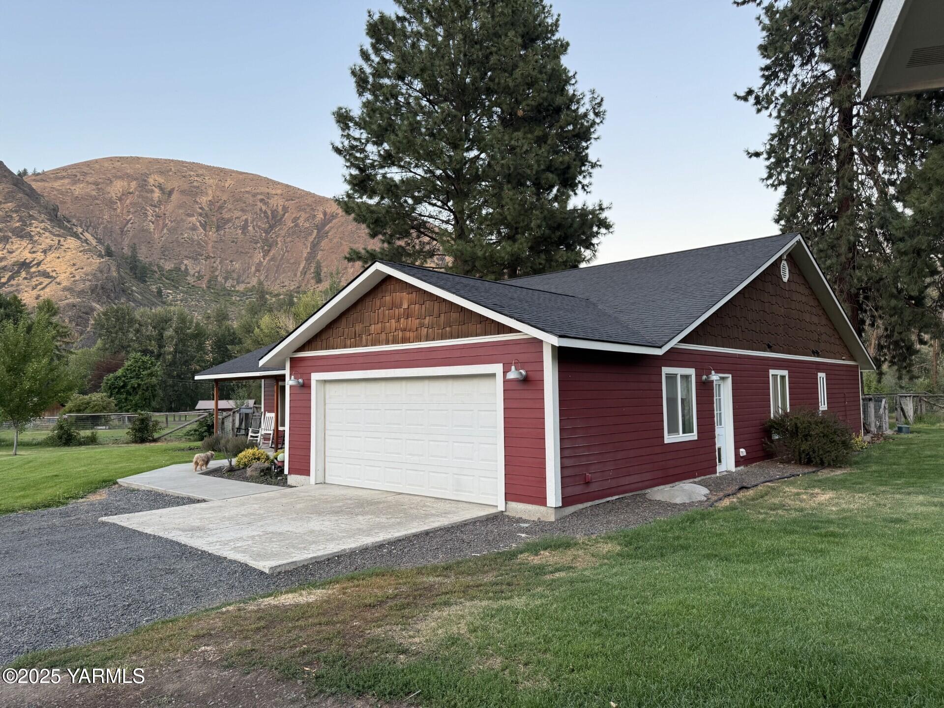 121 Rattlesnake Lane Naches, WA 98937 - Photo 2 of 45 a view of a yard in front of a house with large tree