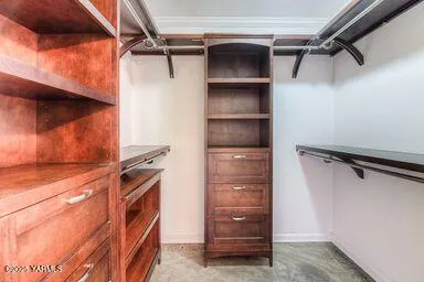 a view of walk in closet with clothes and shoes