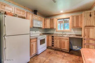 a kitchen with granite countertop a refrigerator stove top oven and sink