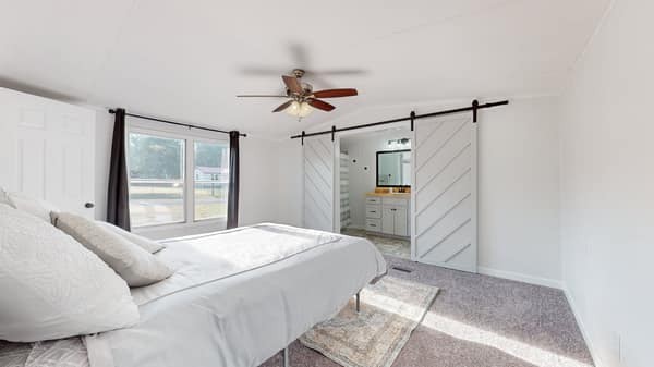 1051 Brandon Hollow Road Lynchburg, TN 37352 - Photo 16 of 36 a bedroom with a large bed and a chandelier