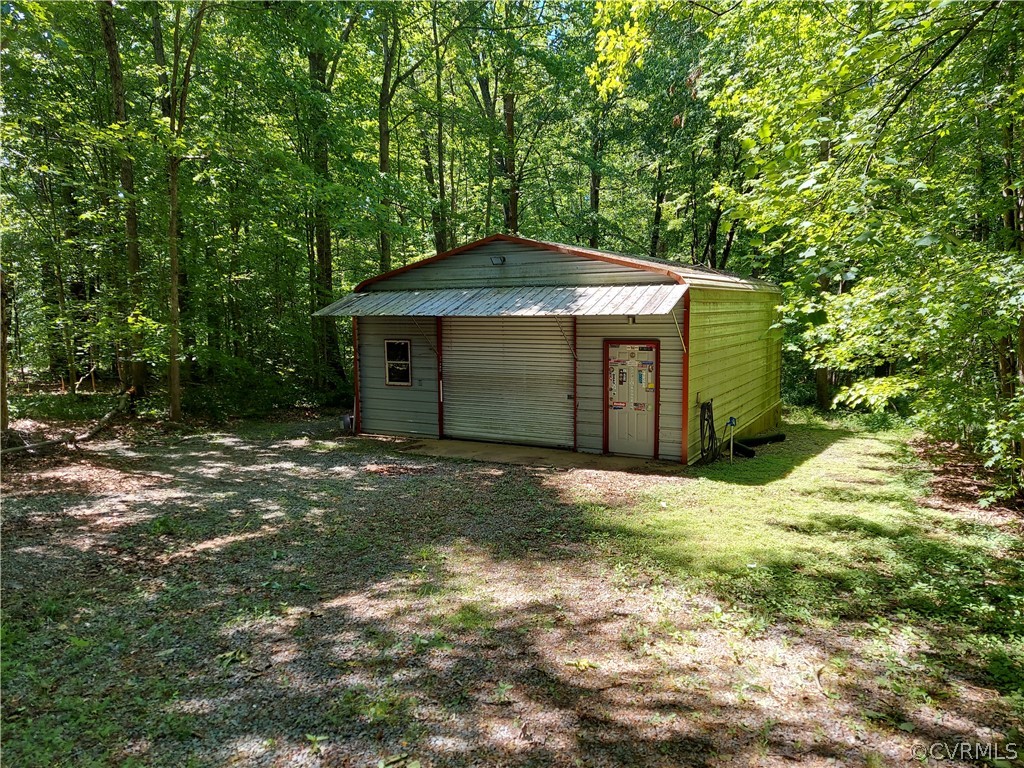 4263 Broad St Road Gum Spring, VA 23065 - Photo 30 of 39 a backyard of a house with large trees and outdoor seating