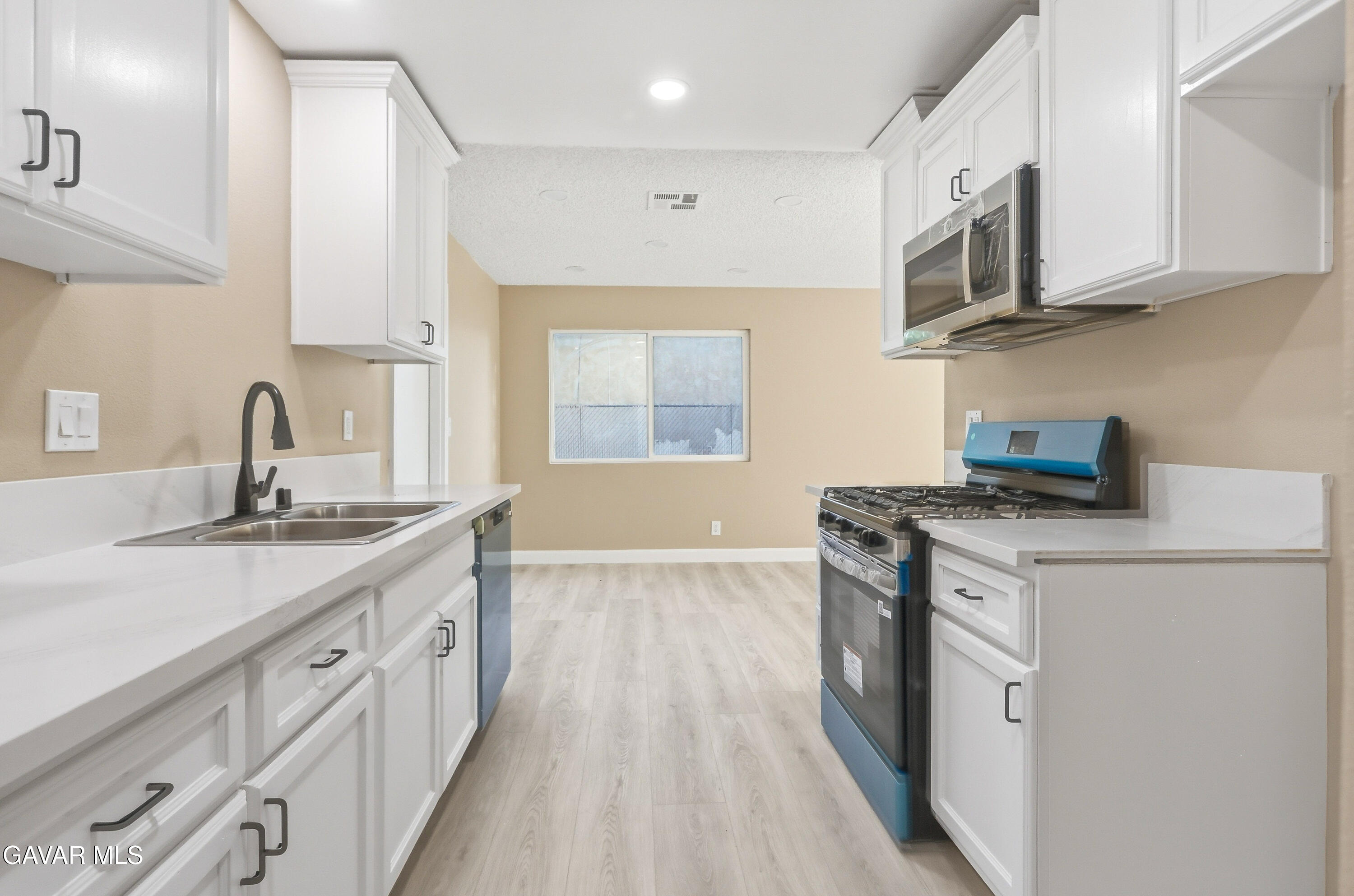 3340 West Roxbury Street Rosamond, CA 93560 - Photo 13 of 20 a kitchen with stainless steel appliances granite countertop a sink stove and cabinets
