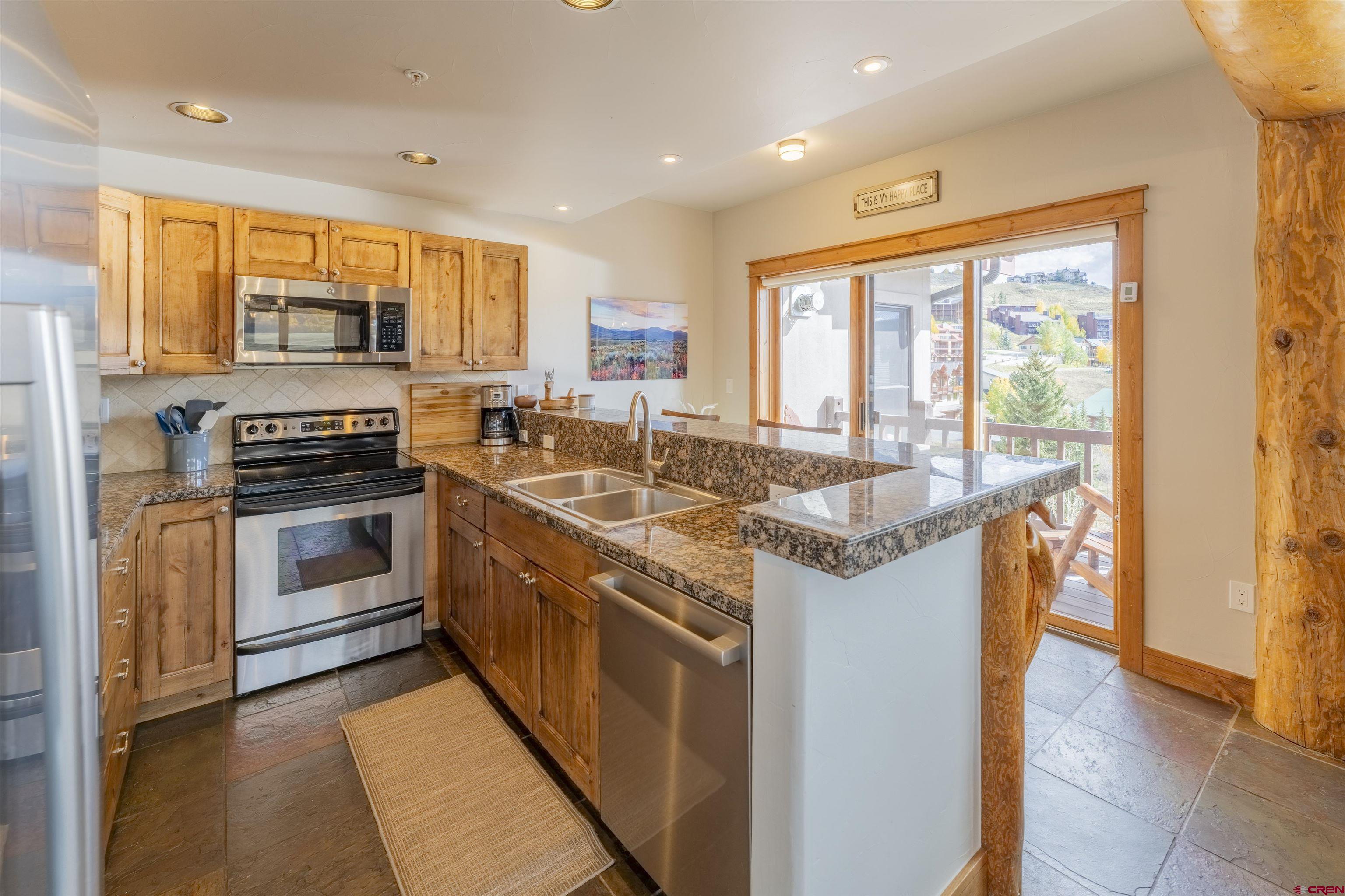 9 Hunter Hill Road, Unit 301 Crested Butte, CO 81225 - Photo 11 of 44 a kitchen with stainless steel appliances granite countertop a stove a sink and a refrigerator