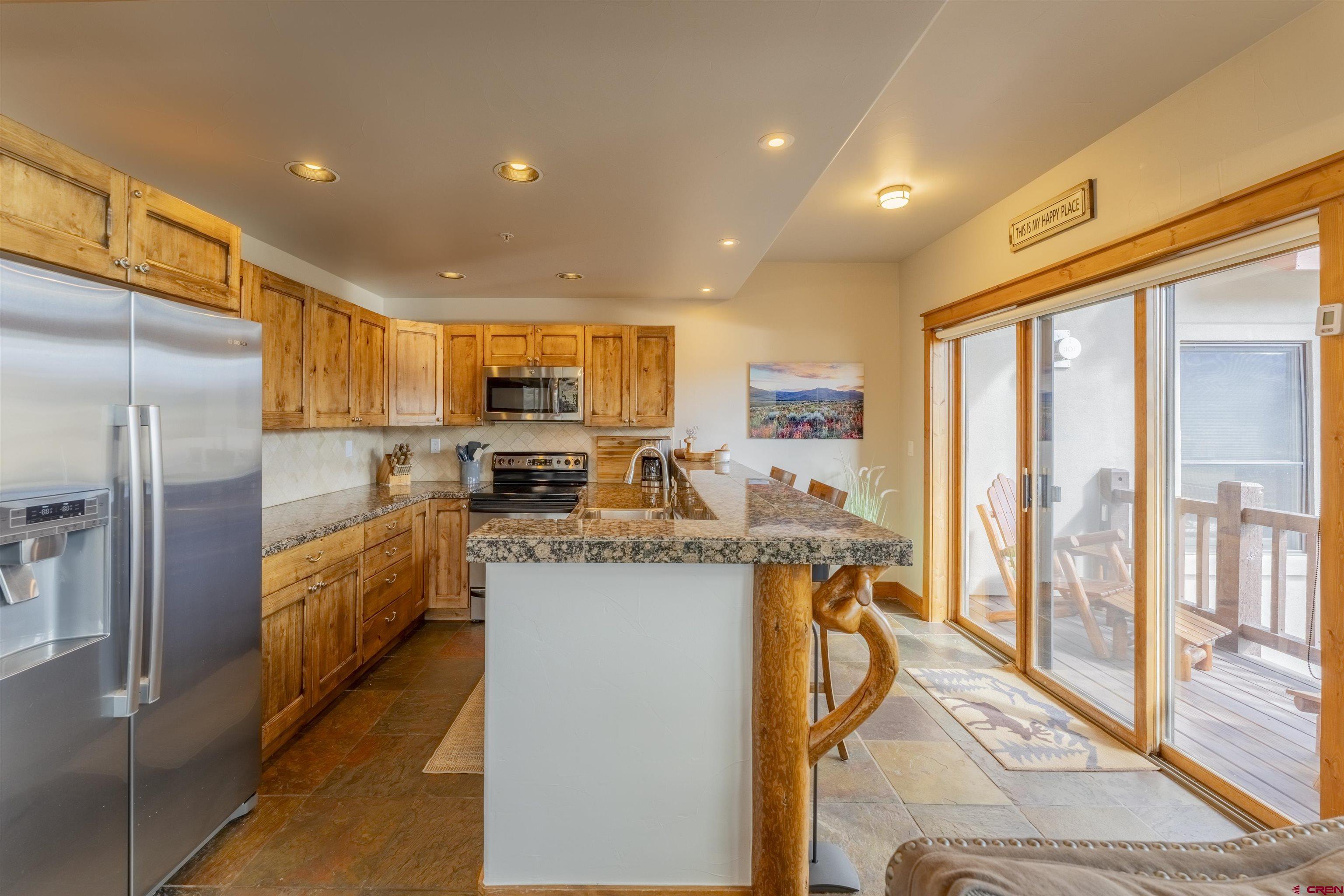 9 Hunter Hill Road, Unit 301 Crested Butte, CO 81225 - Photo 12 of 44 a kitchen with stainless steel appliances granite countertop a refrigerator and a stove top oven