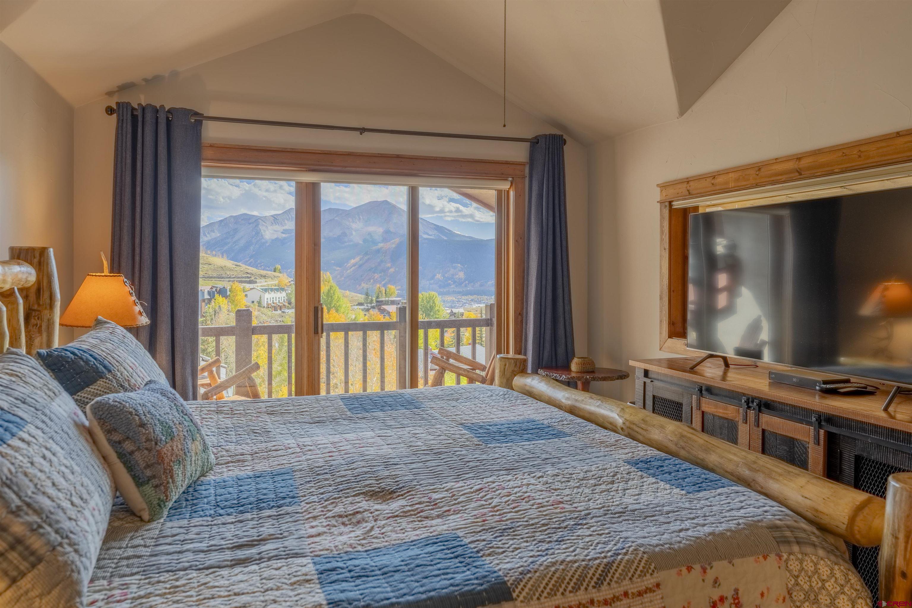 9 Hunter Hill Road, Unit 301 Crested Butte, CO 81225 - Photo 22 of 44 a bedroom with a bed and a flat tv screen on dresser