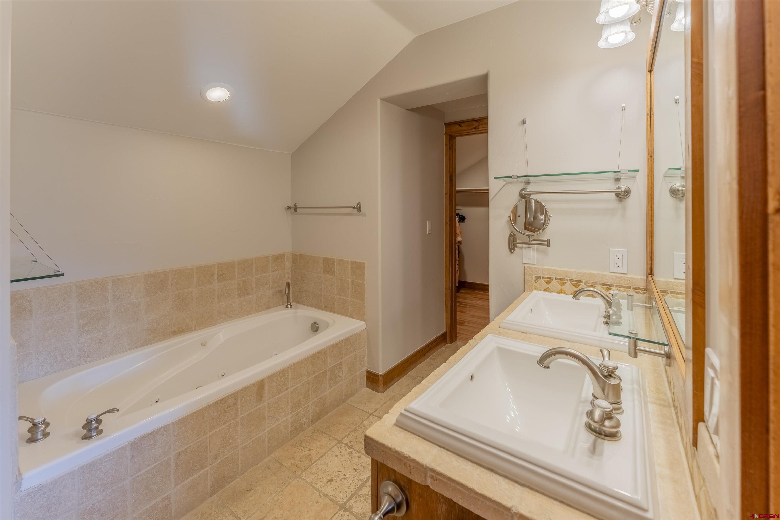 9 Hunter Hill Road, Unit 301 Crested Butte, CO 81225 - Photo 27 of 44 a bathroom with a sink and mirror with bathtub
