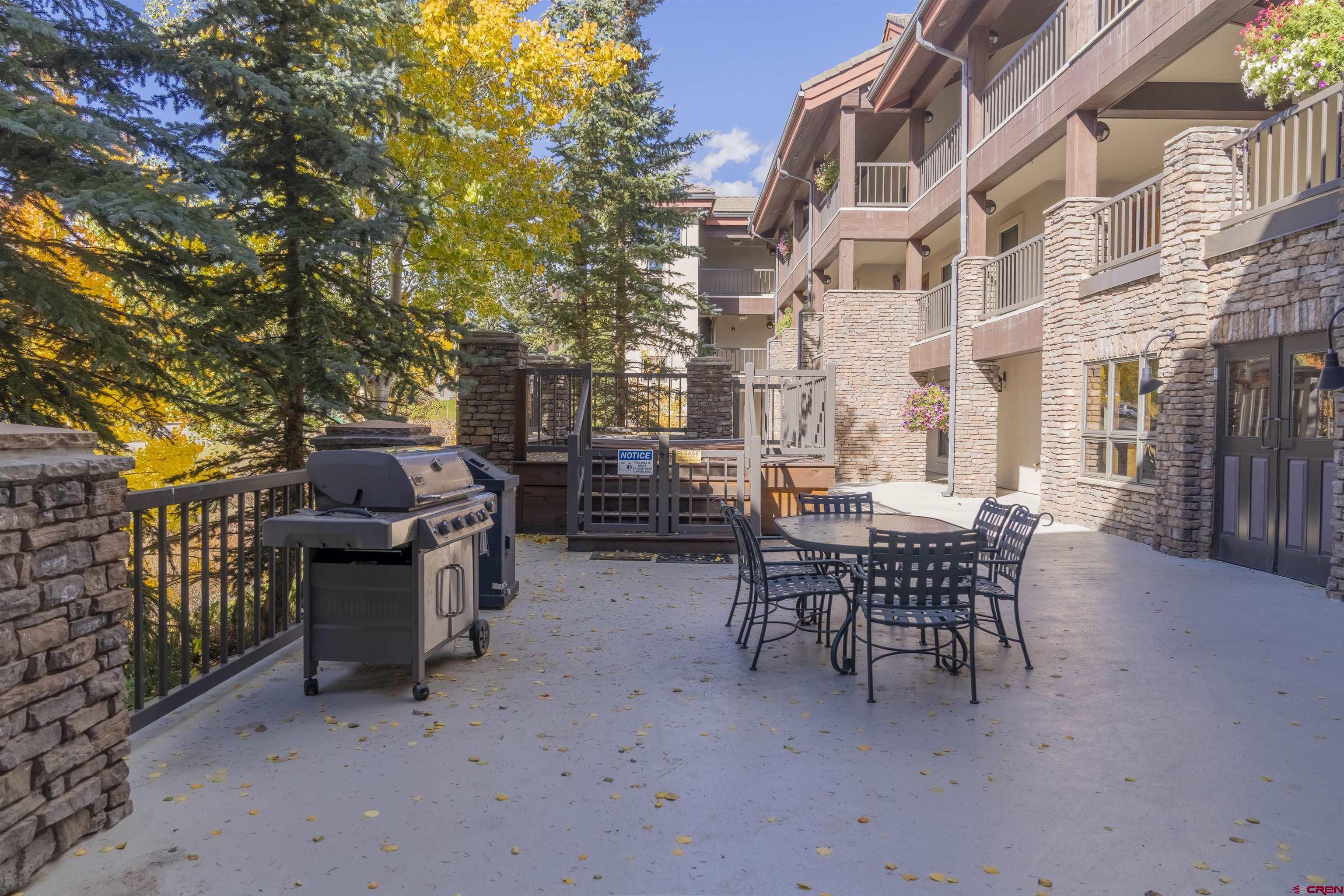 9 Hunter Hill Road, Unit 301 Crested Butte, CO 81225 - Photo 37 of 44 a backyard of a house with barbeque oven table and chairs