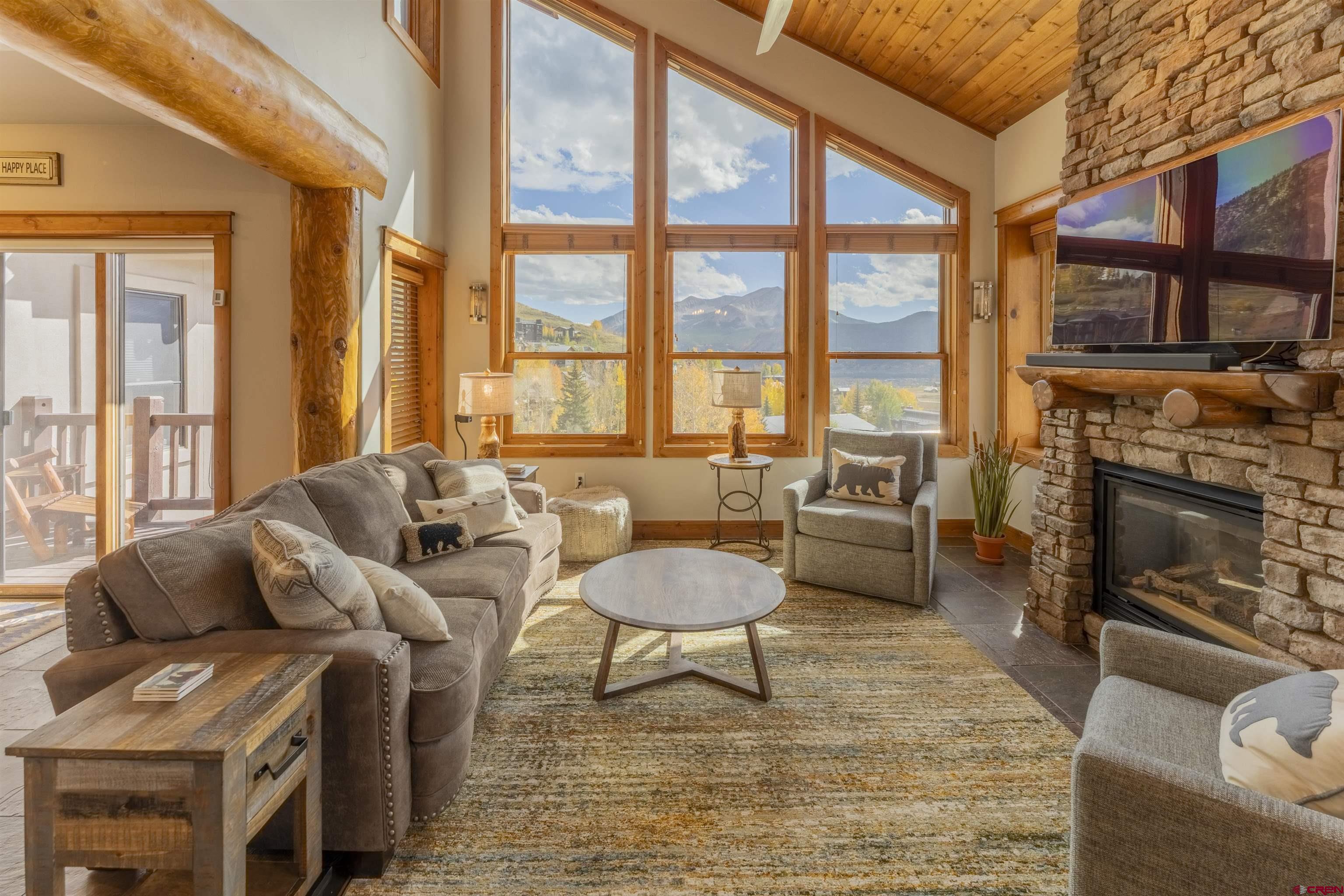 9 Hunter Hill Road, Unit 301 Crested Butte, CO 81225 - Photo 6 of 44 a living room with furniture a fireplace and a large window