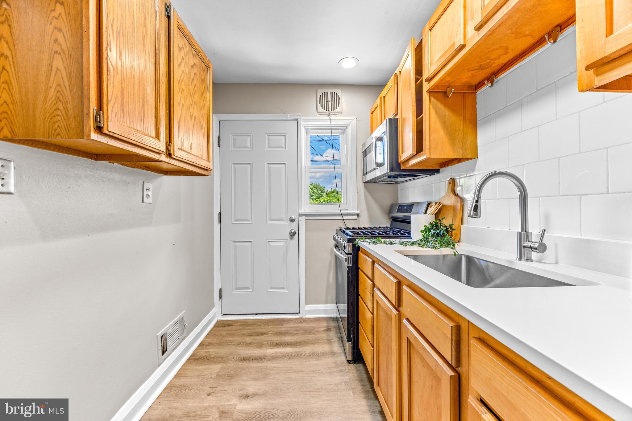 8450 Kavanagh Road Dundalk, MD 21222 - Photo 12 of 32 a kitchen with stainless steel appliances a sink and cabinets